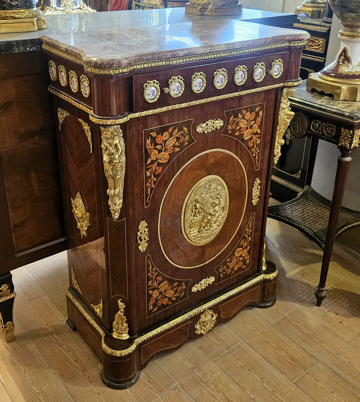 The Gilded Emblem – French-Inspired Marble-Top Commode with Ornate Floral Medallion & Luxurious Gold Accents